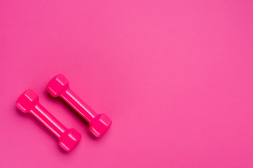 top shot of two dumbbells on pink background with copy space
