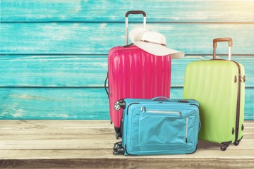 Colorful suitcases stack on wooden background