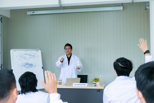 Blurred of professor or doctor teaching about the lab fish anatomy to young scientists and veterinarians doctor. Shooting picture from the back of room.