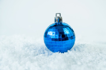 Blue Christmas ball in the snow on a white background.