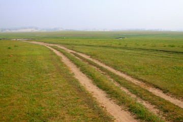 Fototapeta na wymiar unsurfaced road in the WuLanBuTong grassland, China