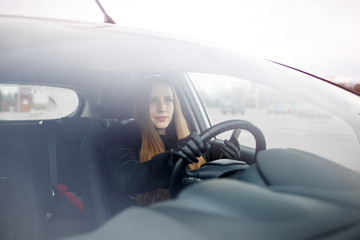 Fototapeta premium Young lady driving a car in winter