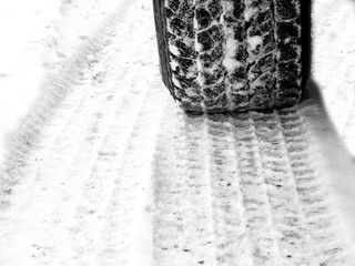 Car tires in snow on road icy slick tread