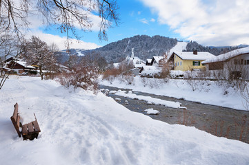 Fototapeta na wymiar Rast an der Loisach, idyllische Winterlandschaft Garmisch-Partenkirchen mit Bank