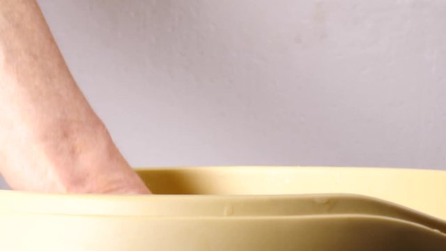 Close up slow motion shot of unrecognizable woman putting hand into paraffin bath taking care of hands skin