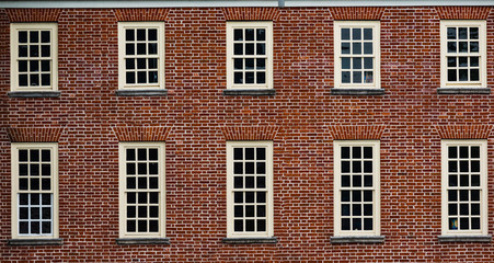 Fototapeta na wymiar Red brick vintage style building facade with multiple windows