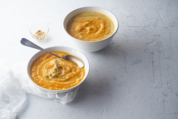 Pureed pumpkin soup with seeds and thyme. Warm food concept, dieting. Concrete background, overhead view. Copy space