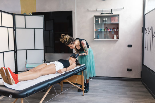 Tattooist attending to customer in parlour