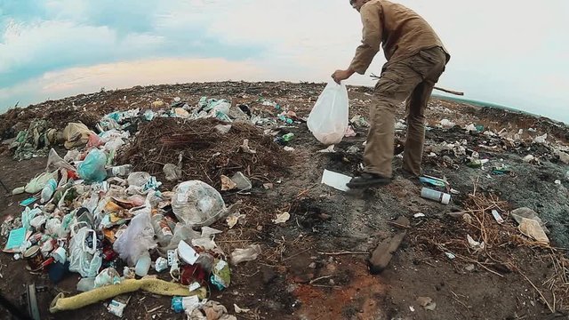 man homeless dump in a landfill homeless looking for food among the garbage. social concept problem poverty lifestyle hunger man. problem of poverty and social inequality concept