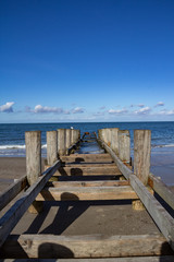 Ein alter Bootssteg führt vom Strand in die Ostsee