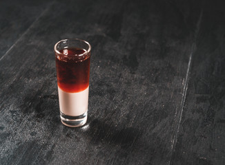 Glasses with an alcoholic drink on a black wooden table