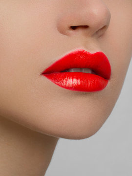 The macro photo of the closed female mouth. Chubby lips with red lipstick show a fashionable make-up and increase in lips. Cosmetology, Spa, cosmetics