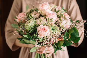 Woman holding bouquet of fresh soft pink roses