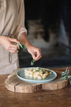 Potato gnocchi on plate being garnished
