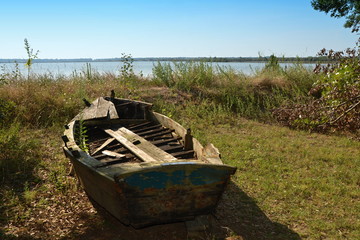 Detail of a ship on a dry shore near Ravenna, A wooden boat on the shore of a lake, Shore, lake, grass, boat, wooden, water, lake, italy, vacation, green, brown,