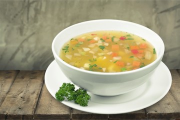 Bowl of delicious soup on wooden table