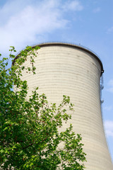 heavy industrial water cooling tower and the green tree