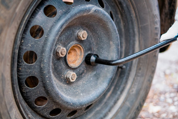 Tightening the nuts on the wheel of the car. Socket wrench.