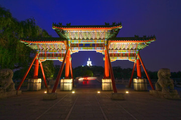 White pagoda architectural and memorial arch night scene in the Beihai Park，Beijing, China