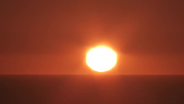 Time lapse of sunrise night to day over ocean horizon on warm and clear sky.