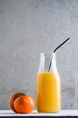 orange juice in a bottle with a reuseable metal straw