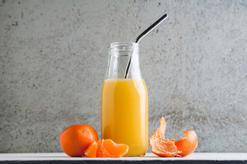 orange juice in a bottle with a reuseable metal straw