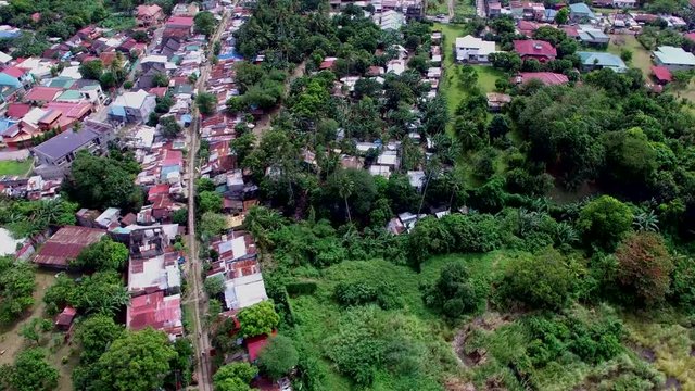 San Pablo City, Laguna, Philippines - January 26, 2018: Roofs of slum and squatter houses built along railway road in a messy, ill planned city housing community. drone aerial