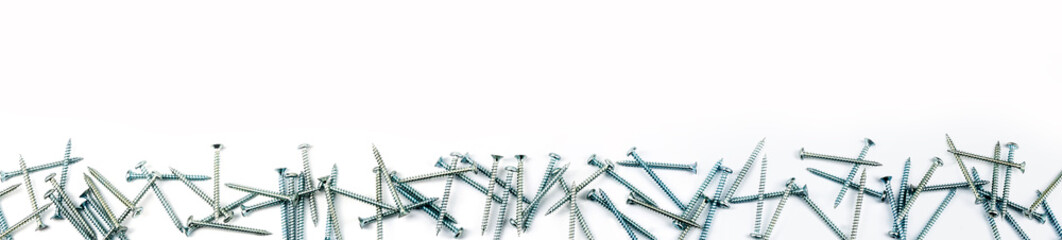 some screws, bolts on a white background, panorama - obrazy, fototapety, plakaty