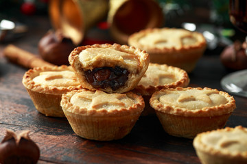 British Christmas mince pies with decoration, gifts, green tree branch on wooden rustic table