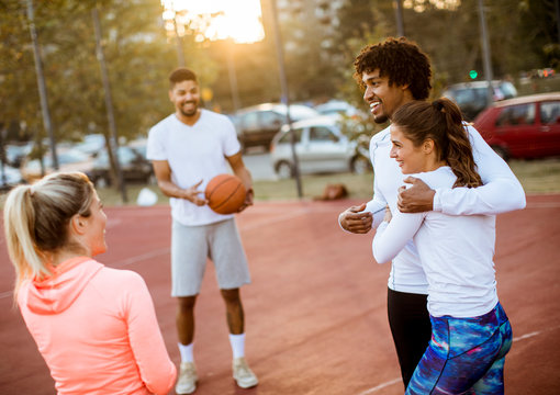 Group of multiethnic people  playing basketball on court