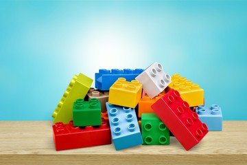 Toy colorful plastic blocks on blue background