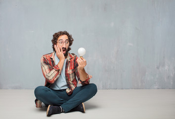 young crazy mad man  fool pose with a light bulb. idea or inspir - obrazy, fototapety, plakaty