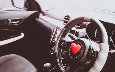 Fototapeta na wymiar Steering wheel with heart red object.Love car concept idea.interior console car.