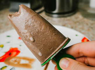Chocolate ice cream on a stick in his hand