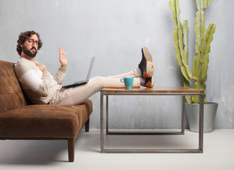 young bearded man sitting on a leather sofa in a vintage living room