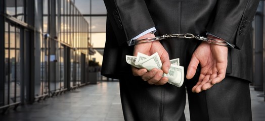 Cropped image of male hands in handcuffs behind his back