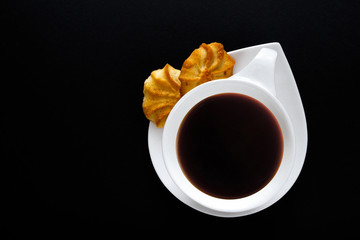 White cup of coffee on a black background close-up with copy space for text in minimalism style. Flat lay top view