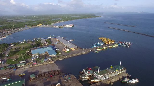 Dalahican, Lucena City, Philippines - December 28, 2017: View of fishing port and dock yard where boats are anchored side by side. Drone Aerial