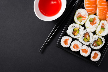 Naklejki  Japońskie jedzenie: sushi maki i nigiri na czarnym tle. Płaska kompozycja top-down. Copyspace