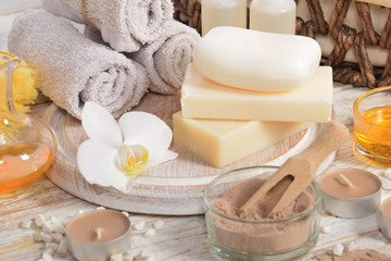 Fototapeta na wymiar gray soap dry powder for making mud face masks and natural vegetable oils in the company of flowers