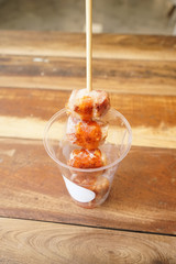 grilled sausage wrapped and rolled over with becon, dropping sweet chilli sauce. Put it in plastic cup, ready to serve.