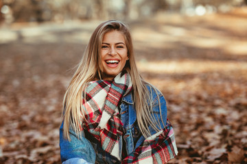 Portrait of a beautiful blonde with a smile on face in the park