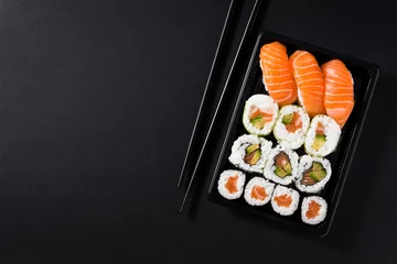 Crédence de cuisine en verre imprimé Bar à sushi Cuisine japonaise : sushi maki et nigiri sur fond noir. Composition de haut en bas à plat. Espace de copie