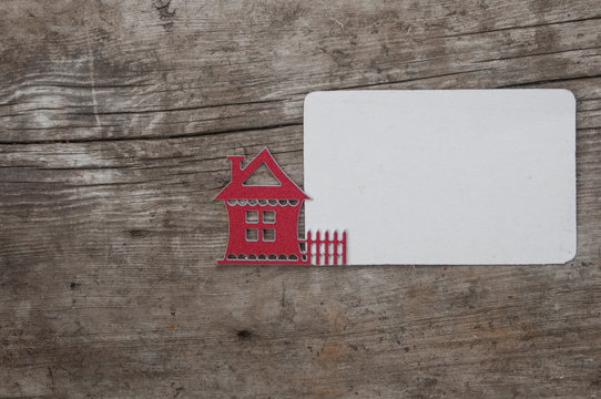 Key with house icon and white blank paper on wooden background