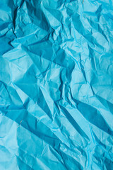 Obraz premium A crumpled blue sheet of paper. Vertical background.