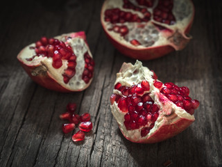 Ripe red fresh pomegranate fruit on wooden rustic background. Healthy food, closeup, flat lay, top view