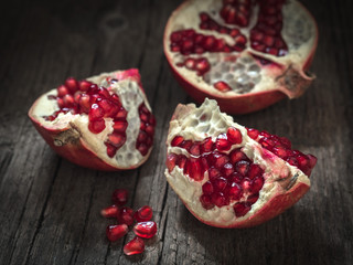 Ripe red fresh pomegranate fruit on wooden rustic background. Healthy food, closeup, flat lay, top view