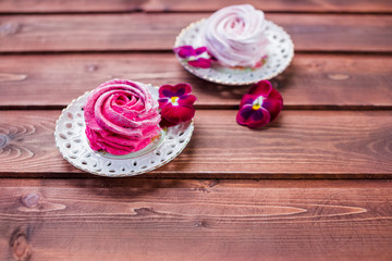 Sweet dessert white,pink zephyr marshmallows on clay plate and rustic wooden background.Marshmallow, Meringue, Zephyr. Selective focus.Copy space