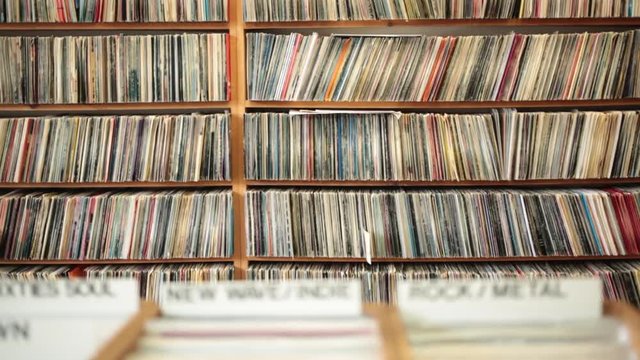 Dolly shot of racks of LP vinyl records on display in music store