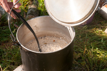 Fototapeta premium Camping food. Distribution of porridge in the campaign in the early morningssel